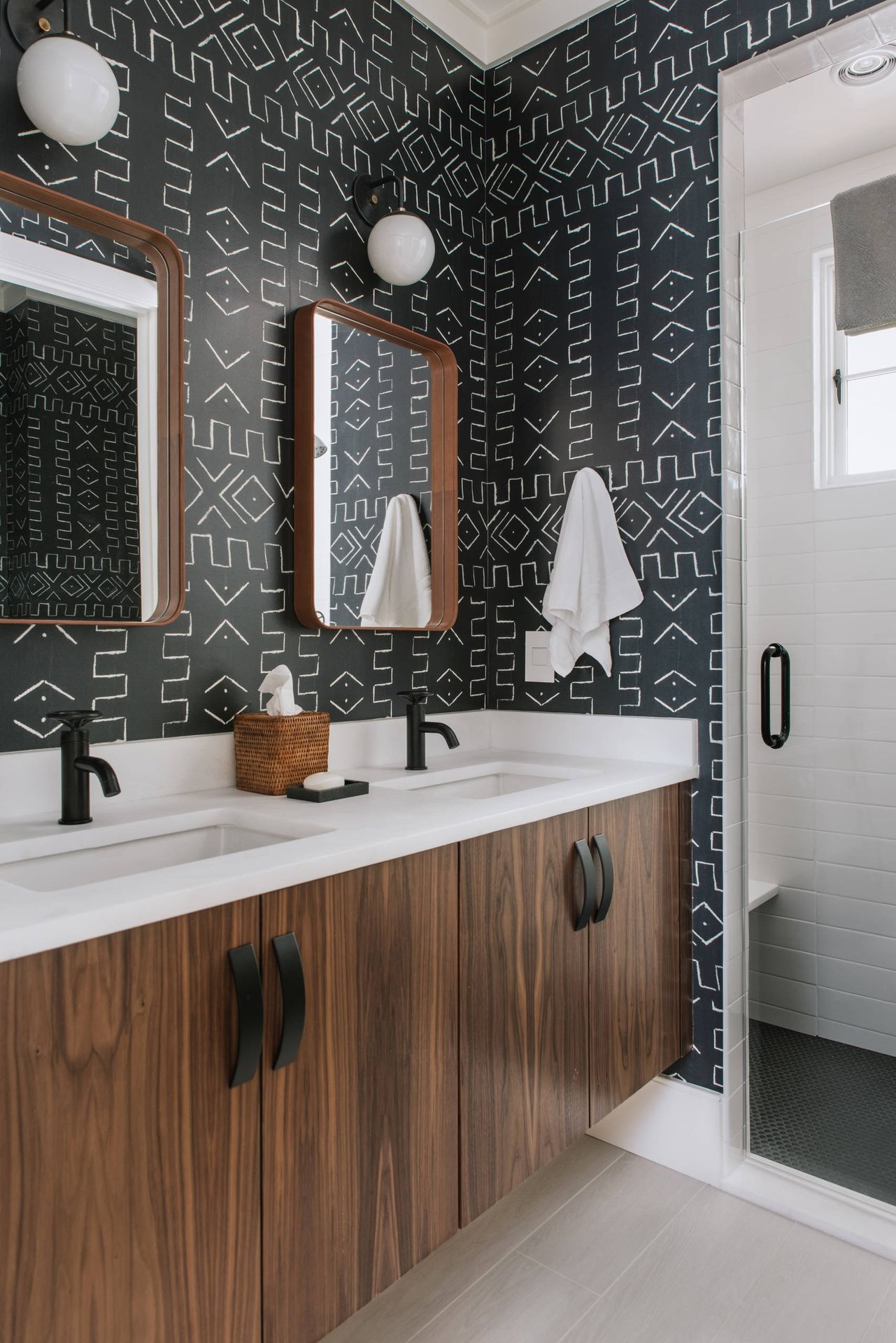 Salle de bain de luxe avec double lavabo et papier peint noir
