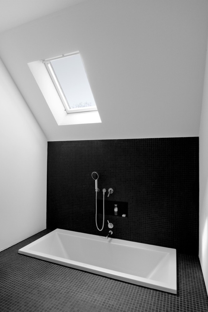 Sunken bathtub in minimalist bathroom by Nils Wenk